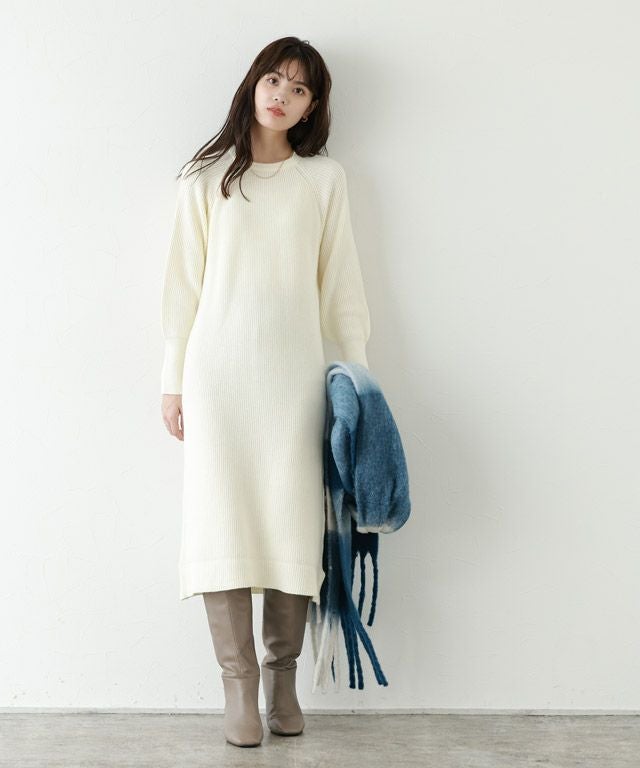 Woman in ivory sweater dress and tall boots